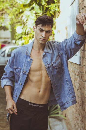 Man Wearing Blue Denim Jacket Leaning on Side Wall