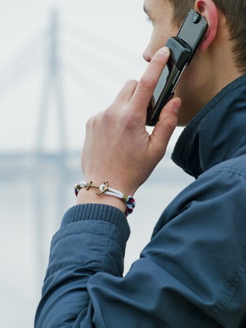 Man Wearing Blue Jacket Using His Mobile Phone
