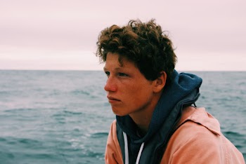 Man Wearing Blue Pullover Hoodie Beside Body of Water