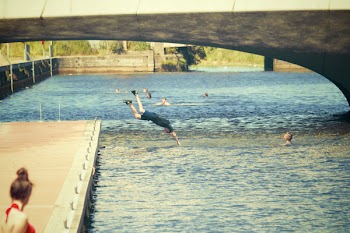 Man Wearing Blue Shirt Jumping on the Body of Water