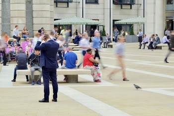 Man Wearing Blue Suit on Beige Ground Near Building