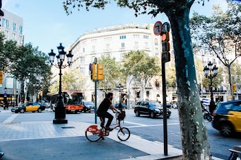 Man Wearing Blue T-shirt Riding Bicycle on Street