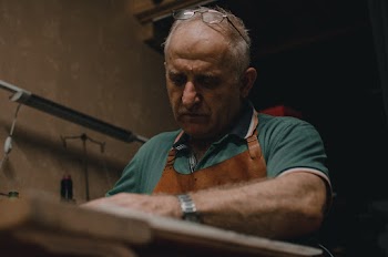 Man Wearing Brown Apron and Teal Polo Shirt