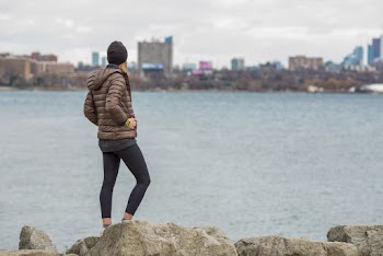 Man Wearing Brown Bubble Jacket Standing Near the Ocean