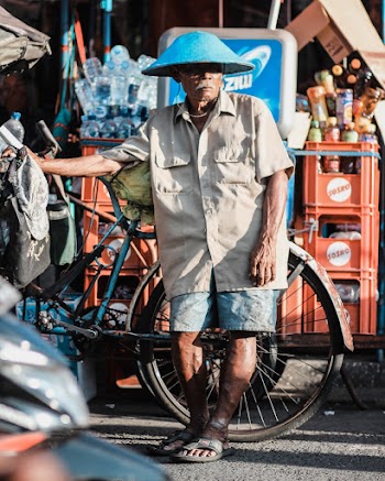 Man Wearing Brown Dress Shirt Besides Blue Bicycle