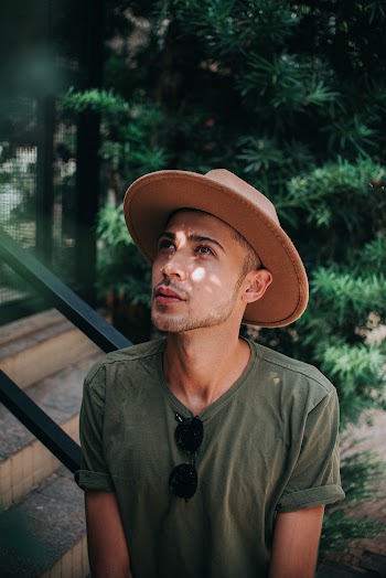 Man Wearing Brown Hat Looking Up Outside Building