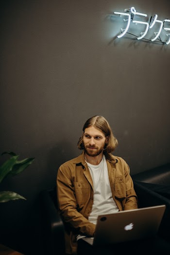 Man Wearing Brown Jacket Using Laptop Computer