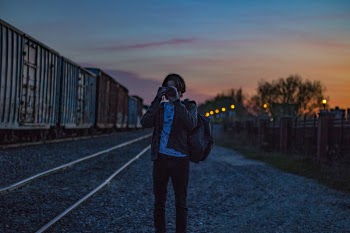Man Wearing Brown Jacket With Backpack Taking Photo during Golden Hour