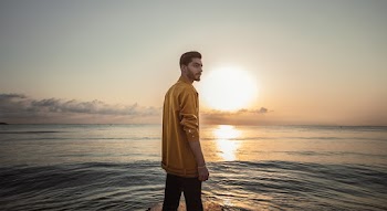 Man Wearing Brown Top Standing on Seashore