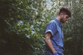 man wearing chambray button-up shirt in forest