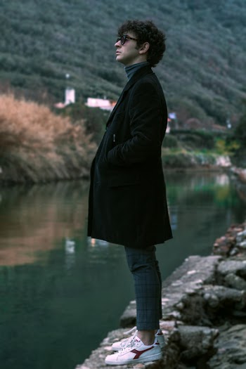 Man Wearing Coat Standing Beside Body of Water
