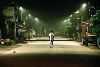 Man Wearing Crew-neck T-shirt Walking on Gray Pathway during Nighttime