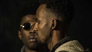 Man Wearing Earphones Near Man in Sunglasses