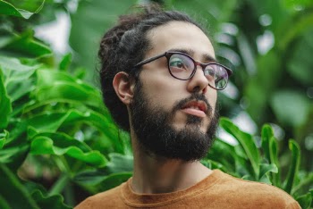 Man Wearing Eyeglasses Near Green-Leafed Plants