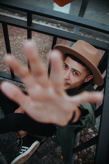 Man Wearing Fedora While Showing His Left Hand
