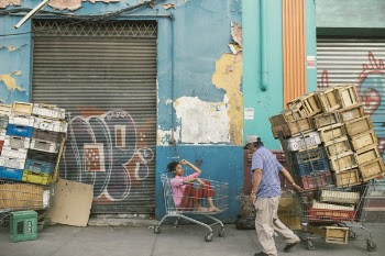 Man Wearing Gray Cap and Blue Shirt Holding Shopping Cart