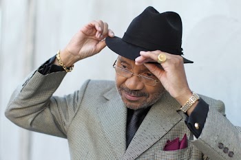 Man Wearing Gray Coat Holding His Fedora Hat