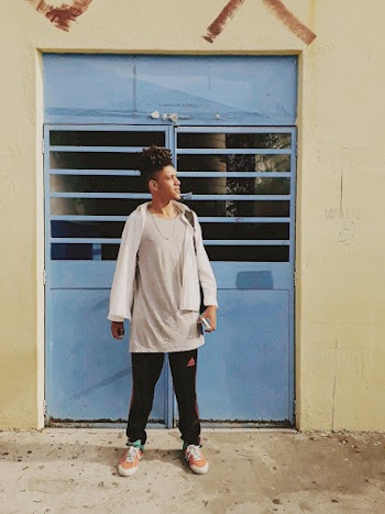 Man Wearing Gray Crew-neck Shirt and Black Pants Near Blue Metal Door
