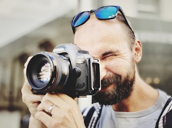 Man Wearing Gray Crew Neck Shirt Taking Photo Using Black Canon Camera