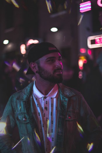 Man Wearing Gray Denim Jacket and Black Cap at Night