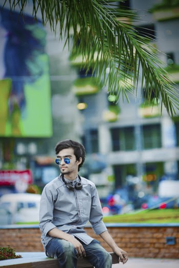 Man Wearing Gray Dress Shirt Sitting on Bench Near Building