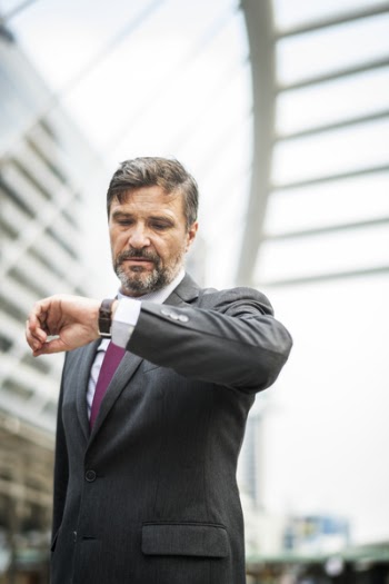 Man Wearing Gray Formal Coat Looking at his Watch