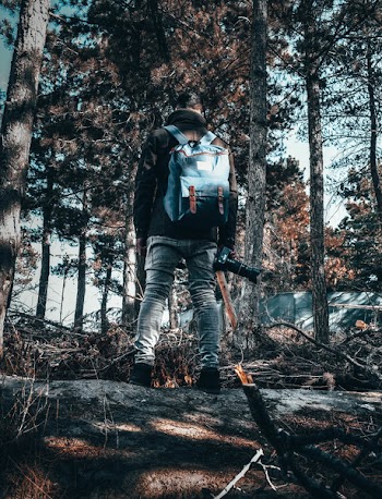 Man Wearing Gray Pants Standing Beside Trees