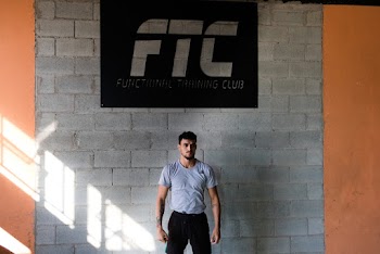 Man Wearing Gray Shirt Standing Near Wall