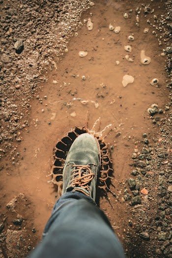 Man Wearing Gray Shoe Standing on Brown Soil