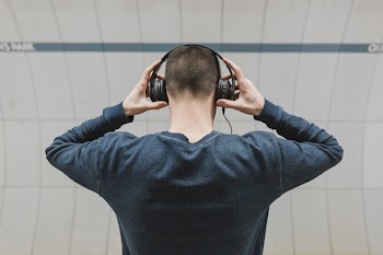 Man Wearing Gray Sweatshirt and Headphones