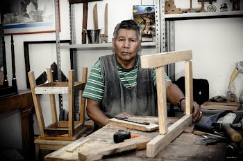 Man Wearing Green and White Stripe Shirt Holding Beige Wooden Frame on Table
