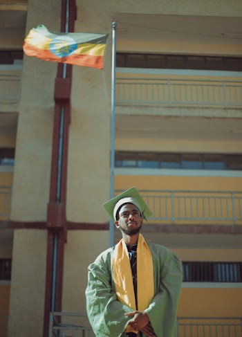 Man Wearing Green and Yellow Graduation Gown
