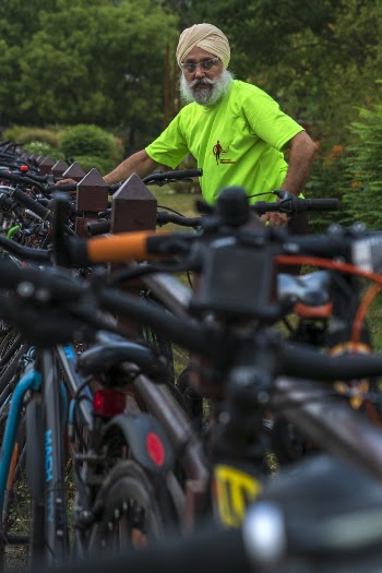 Man Wearing  Green Crew-neck T-shirt Beside Parked Bikes