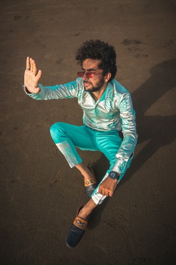Man Wearing Green Dress Shirt Sitting on Sand