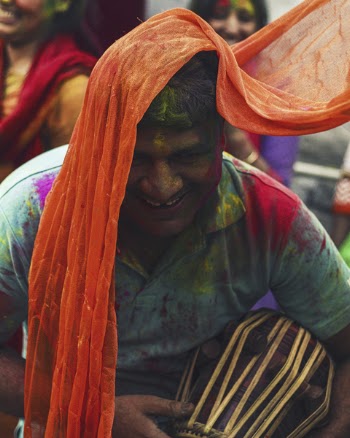 Man Wearing Green Polo Shirt Covered in Colored Powder Smiling