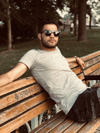 Man Wearing Grey Crew Neck Shirt Sitting On Brown Wooden Bench