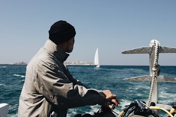 Man Wearing Grey Jacket  In A Watercraft Out At Sea