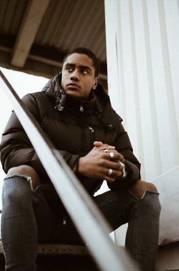 man wearing jacket sitting on stairs