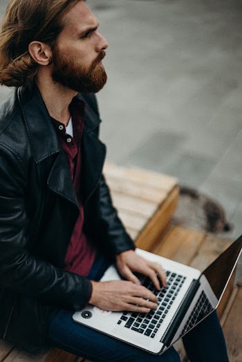 Man Wearing Leather Jacket Using Laptop