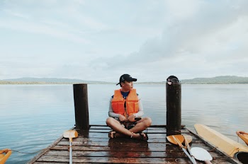 Man Wearing Life Vest While Sitting On The Dock