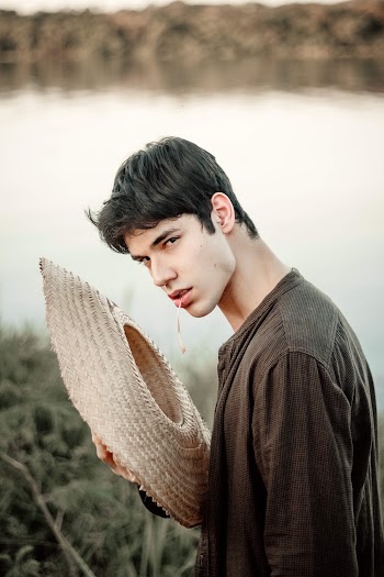 Man Wearing Long Sleeve Shirt Holding Brown Sun Hat 