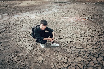 Man Wearing Long-sleeved Shirt Sitting on Empty Area