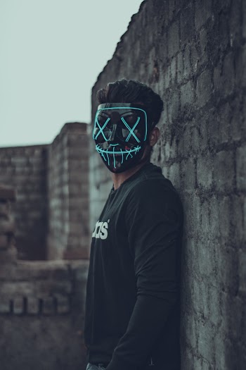 Man Wearing Mask Leaning On Wall