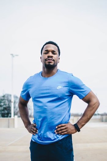 man wearing Nike shirt with hands on waist outdoor