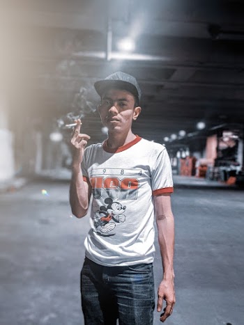 Man Wearing Orange and White Shirt Holding Cigarette Smoking