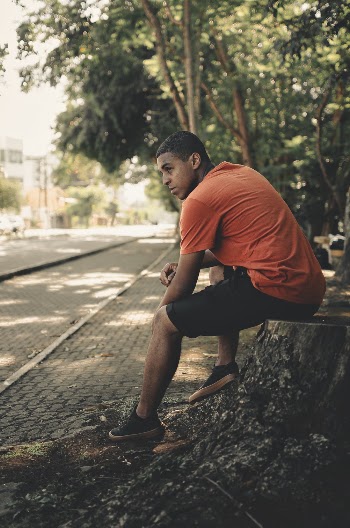 Man Wearing Orange Crew-neck Shirt and Black Cargo Shorts 