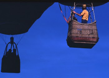 Man Wearing Orange T-shirt Riding on Brown Parachute