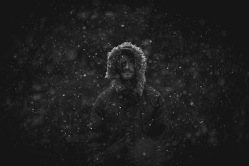 man wearing parka jacket in snow