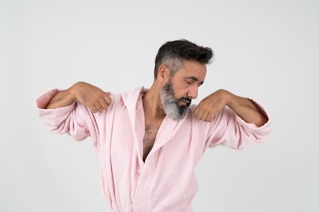 Man Wearing Pink Bathrobe With Both Hands on Shoulder