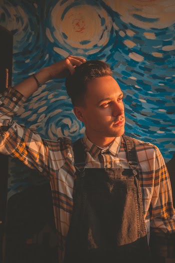 Man Wearing Plaid Shirt Standing in Front of Painting